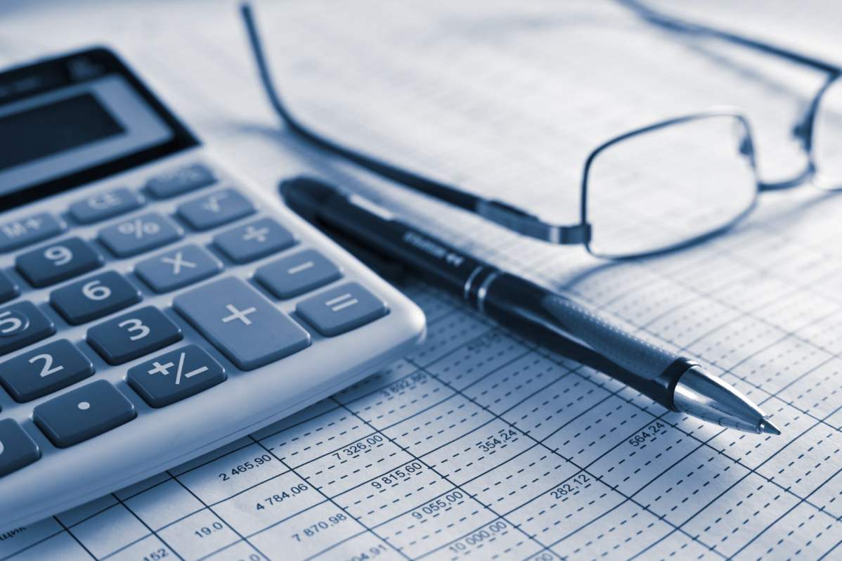 Auf einer Abrechnung liegt ein Taschenrechner und eine Lesebrille