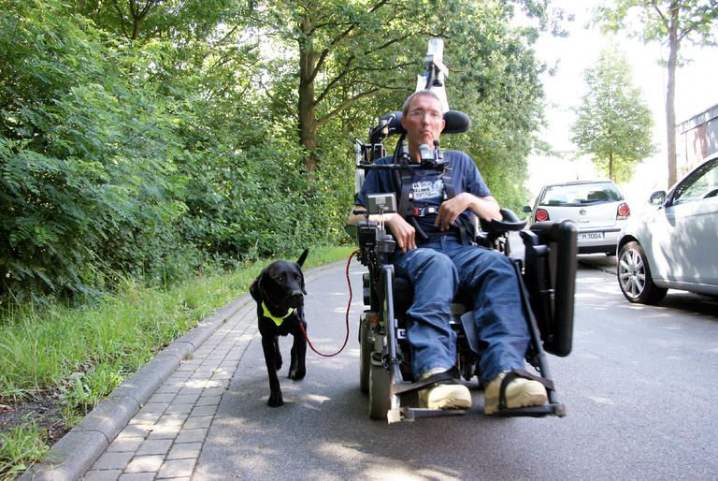 Jürgen Manthey mit seiner Begleithündin Minou, die neben seinem Elecktrorollstuhl brav mitläuft