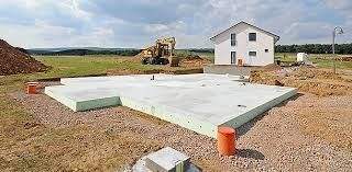 Foto: Eine frischgegossene Bodenplatte für ein neues Familienwohnhaus in einem fast noch leeren Neubaugebiet